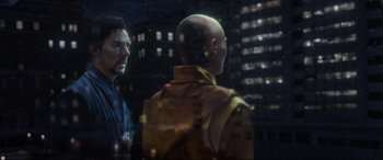 Movie still from “Doctor Strange” (2016), directed by Scott Derrickson – Two men are standing in front of a building; Close Up shot, Over the shoulder angle