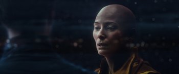 Movie still from “Doctor Strange” (2016), directed by Scott Derrickson – A woman with a bald head looking out of a window; Close Up shot, Over the shoulder angle