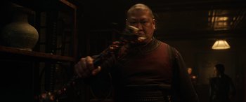 Movie still from “Doctor Strange” (2016), directed by Scott Derrickson – A man holding a microphone in a dark room; Close Up shot, Over the shoulder angle