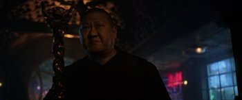 Movie still from “Doctor Strange” (2016), directed by Scott Derrickson – A man in a black shirt is standing in a dark room; Close Up shot, Low angle