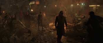 Movie still from “Doctor Strange” (2016), directed by Scott Derrickson – A group of people standing in a room with rubble; Wide shot, Over the shoulder angle