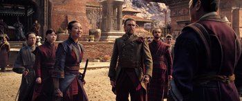 Movie still from “Doctor Strange in the Multiverse of Madness” (2022), directed by Sam Raimi – A group of men and women standing next to each other on a street; Medium shot, Over the shoulder angle