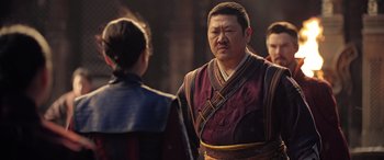 Movie still from “Doctor Strange in the Multiverse of Madness” (2022), directed by Sam Raimi – A man in a red and black outfit standing next to a woman in a red dress; Medium shot, Over the shoulder angle