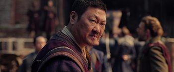 Movie still from “Doctor Strange in the Multiverse of Madness” (2022), directed by Sam Raimi – An older man wearing a purple jacket and looking at the camera; Close Up shot, Low angle