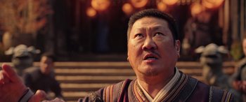 Movie still from “Doctor Strange in the Multiverse of Madness” (2022), directed by Sam Raimi – An older asian man looking up at the sky; Close Up shot, Low angle