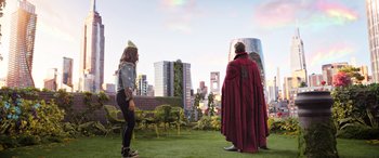 Movie still from “Doctor Strange in the Multiverse of Madness” (2022), directed by Sam Raimi – A couple of people standing on top of a grass covered field; Wide shot, Over the shoulder angle