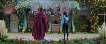 Movie still from “Doctor Strange in the Multiverse of Madness” (2022), directed by Sam Raimi – A man and a woman standing next to each other in front of a building; Wide shot, Over the shoulder angle