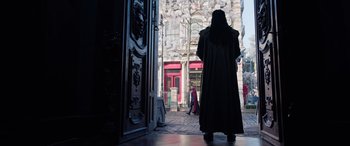 Movie still from “Doctor Strange in the Multiverse of Madness” (2022), directed by Sam Raimi – A man in a black robe stands in front of a building; Wide shot, Low angle