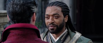 Movie still from “Doctor Strange in the Multiverse of Madness” (2022), directed by Sam Raimi – A person with long dreadlocks; Close Up shot, Over the shoulder angle