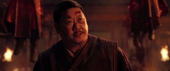Movie still from “Doctor Strange in the Multiverse of Madness” (2022), directed by Sam Raimi – An asian man with bruises on his face; Close Up shot, Low angle