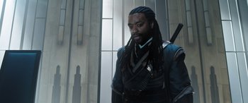 Movie still from “Doctor Strange in the Multiverse of Madness” (2022), directed by Sam Raimi – A man with long dreadlocks is standing in front of a building; Close Up shot, Over the shoulder angle