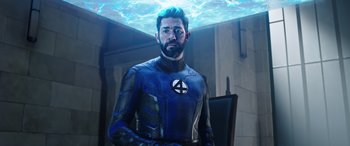 Movie still from “Doctor Strange in the Multiverse of Madness” (2022), directed by Sam Raimi – A man in a blue and black suit standing next to a wall; Medium shot, Over the shoulder angle