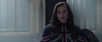 Movie still from “Doctor Strange in the Multiverse of Madness” (2022), directed by Sam Raimi – A woman with long dark brown hair wearing a union jack jacket; Medium shot, Over the shoulder angle