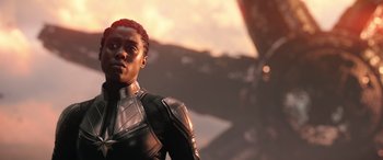 Movie still from “Doctor Strange in the Multiverse of Madness” (2022), directed by Sam Raimi – A man in a black and silver suit standing in front of a sunset; Close Up shot, Over the shoulder angle