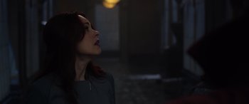 A woman with red hair looking up at the ceiling