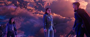 Movie still from “Doctor Strange in the Multiverse of Madness” (2022), directed by Sam Raimi – A woman standing in front of a sky filled with clouds; Medium shot, Low angle