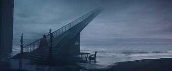 Movie still from “Doctor Strange in the Multiverse of Madness” (2022), directed by Sam Raimi – A chair and table sitting in front of a stair way; Extreme Wide shot, Low angle