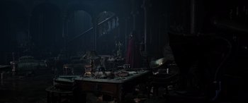 Movie still from “Doctor Strange in the Multiverse of Madness” (2022), directed by Sam Raimi – A man in a red cape standing next to a table; Extreme Wide shot, High angle