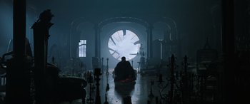 Movie still from “Doctor Strange in the Multiverse of Madness” (2022), directed by Sam Raimi – A man sitting in a room with a clock in the middle of the room; Wide shot, Low angle