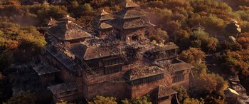 Movie still from “Doctor Strange in the Multiverse of Madness” (2022), directed by Sam Raimi – An aerial view of an old building in the middle of a forest; Extreme Wide shot, Overhead angle