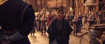 Movie still from “Doctor Strange in the Multiverse of Madness” (2022), directed by Sam Raimi – A person in a crowd of people wearing robes; Medium shot, Over the shoulder angle