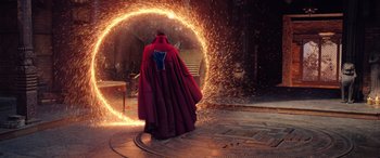 Movie still from “Doctor Strange in the Multiverse of Madness” (2022), directed by Sam Raimi – A man in a red cape standing in front of a fire circle; Wide shot, High angle