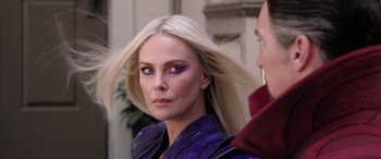 Movie still from “Doctor Strange in the Multiverse of Madness” (2022), directed by Sam Raimi – A woman in a purple jacket with purple eye shadow; Close Up shot, Over the shoulder angle
