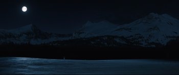 Movie still from “Wind River” (2017), directed by Taylor Sheridan – A snowy mountain with a dark sky in the background; Extreme Wide shot, High angle