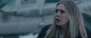 Movie still from “Wind River” (2017), directed by Taylor Sheridan – A young woman is standing in the rain; Close Up shot, Over the shoulder angle
