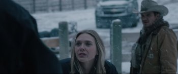 Movie still from “Wind River” (2017), directed by Taylor Sheridan – A woman in a black jacket standing in the snow; Close Up shot, Over the shoulder angle