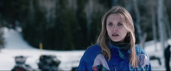 Movie still from “Wind River” (2017), directed by Taylor Sheridan – A woman in a blue jacket standing in the snow; Close Up shot, Over the shoulder angle