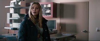 Movie still from “Wind River” (2017), directed by Taylor Sheridan – A woman standing in front of a table in a room; Close Up shot, Over the shoulder angle