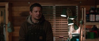 Movie still from “Wind River” (2017), directed by Taylor Sheridan – A man standing in front of a window in a room; Medium shot, Over the shoulder angle