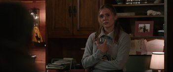 Movie still from “Wind River” (2017), directed by Taylor Sheridan – A woman holding a glass in her hands; Medium shot, Over the shoulder angle