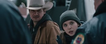 Movie still from “Wind River” (2017), directed by Taylor Sheridan – A man and a woman wearing hats standing next to each other; Close Up shot, Over the shoulder angle