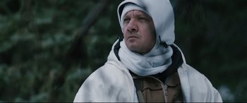 Movie still from “Wind River” (2017), directed by Taylor Sheridan – A man wearing a white hood and a brown jacket; Close Up shot, Low angle