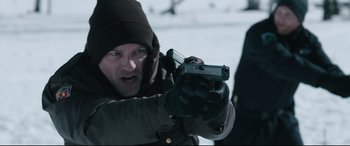 Movie still from “Wind River” (2017), directed by Taylor Sheridan – A man holding a gun while standing in the snow; Close Up shot, Over the shoulder angle