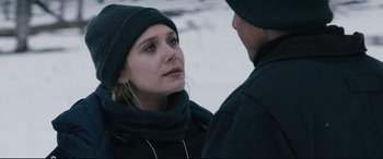 Movie still from “Wind River” (2017), directed by Taylor Sheridan – A woman wearing a hat and a scarf is talking to a man in the snow; Close Up shot, Over the shoulder angle