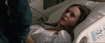 Movie still from “Wind River” (2017), directed by Taylor Sheridan – A woman laying in a hospital bed looking sad; Close Up shot, Over the shoulder angle