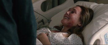 Movie still from “Wind River” (2017), directed by Taylor Sheridan – A young woman in a hospital bed smiling; Close Up shot, Over the shoulder angle