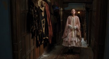 Movie still from “Dolittle” (2020), directed by Stephen Gaghan – A young girl in a pink dress in front of a wall of clothes; Medium shot, Over the shoulder angle