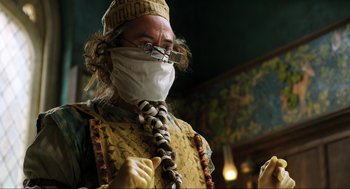 Movie still from “Dolittle” (2020), directed by Stephen Gaghan – A man wearing a face mask standing in front of a painting; Close Up shot, Low angle