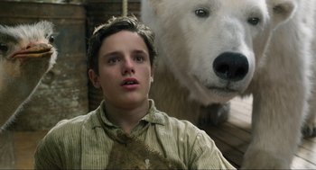 Movie still from “Dolittle” (2020), directed by Stephen Gaghan – A young man standing next to a large polar bear; Close Up shot, Low angle