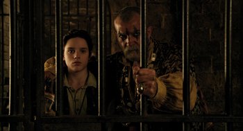 Movie still from “Dolittle” (2020), directed by Stephen Gaghan – A man and a boy behind bars in a jail cell; Medium shot, Low angle