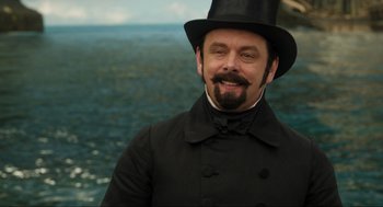 Movie still from “Dolittle” (2020), directed by Stephen Gaghan – A man in a top hat and a long beard; Close Up shot, Over the shoulder angle