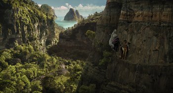 Movie still from “Dolittle” (2020), directed by Stephen Gaghan – Two people are climbing up a cliff on a mountain side; Extreme Wide shot, Overhead angle