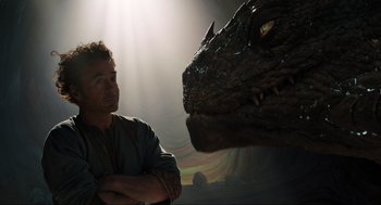 Movie still from “Dolittle” (2020), directed by Stephen Gaghan – A man standing in front of a large dragon head; Medium shot, Over the shoulder angle