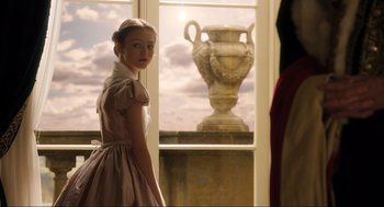 Movie still from “Dolittle” (2020), directed by Stephen Gaghan – A girl in a dress standing in front of a window; Medium shot, Low angle