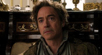 Movie still from “Dolittle” (2020), directed by Stephen Gaghan – A person sitting in front of a table; Close Up shot, Over the shoulder angle