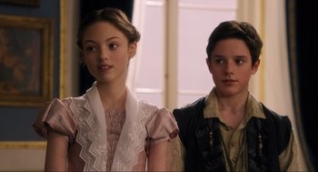 Movie still from “Dolittle” (2020), directed by Stephen Gaghan – A girl and a boy standing next to each other in front of a window; Close Up shot, Over the shoulder angle